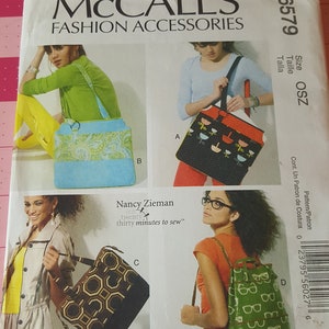 May include: A sewing pattern for four different bags. The bags are shown in various colors and patterns, including a blue and green bag with a paisley design, a black and red bag with a bird design, a brown and black bag with a geometric design, and a green bag with a glasses design. The pattern is titled "McCall's Fashion Accessories" and includes the number "M6579".