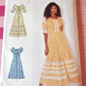 May include: Simplicity sewing pattern showing a woman in a yellow floral dress with white lace trim. The pattern includes illustrations of two dress designs, one yellow and one blue, with the text "69542" and "Simplicity".