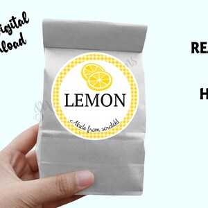 Könnte beinhalten: Ein druckbarer digitaler Download von 5 cm runden Etiketten für selbstgemachte Leckereien. Das Etikett zeigt eine gelbe Zitrone auf einem weißen und gelben Gingham-Hintergrund mit dem Text "LEMON Made from scratch!"