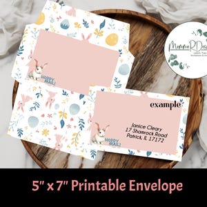 May include: Printable 5x7 inch envelope with a bunny rabbit and floral pattern. The envelope has a pink interior and says "Hoppy Mail!" on the front. The envelope is on a wooden surface.