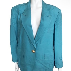 May include: A turquoise blazer with a single gold button closure. The blazer has a notched lapel, two front pockets, and a tailored fit. The garment is displayed on a white mannequin.