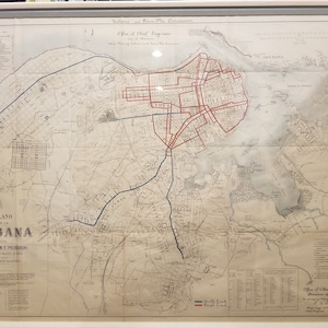 May include: A vintage map of Havana, Cuba, with red and blue lines showing streets and waterways. The map is titled "Plano de la Habana" and includes the text "D. Esteban T. Pichardo" and "Office of Chief Engineer, Division of Walls".