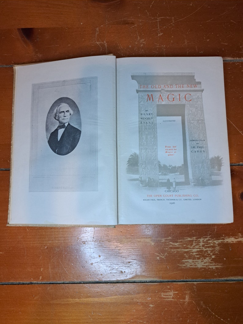 Może przedstawiać: Antyczna książka zatytułowana "The Old and the New Magic" autorstwa Henry'ego Ridgely'ego Evansa, zilustrowana przez dr. Paula Carusa. Okładka książki przedstawia czarno-białe zdjęcie Roberta Houdina, słynnego iluzjonisty.