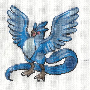May include: A cross-stitch design of a blue bird-like creature with large wings, a long tail, and a red eye. The bird is set against a white background. The cross-stitch is made with various shades of blue thread.
