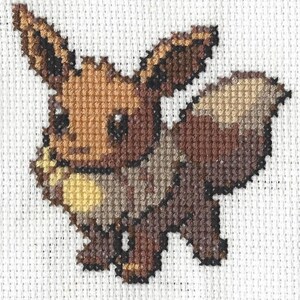 Könnte beinhalten: Kreuzstich eines braunen und beigefarbenen Eevee-Pokémon, einer kleinen fuchsartigen Kreatur mit großen Ohren und einem eingerollten Schwanz.