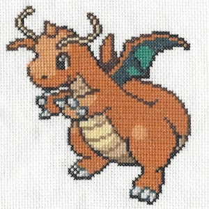 Puede incluir: Un punto de cruz de un dragón de dibujos animados en tonos naranja, beige y verde. El dragón tiene pequeños cuernos, una expresión amigable y sostiene un objeto pequeño. Las alas son verdes y azules. El fondo es blanco.