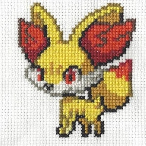 May include: Cross-stitch pattern of a yellow and red fox Pokemon character with black eyes.