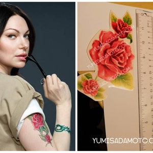 May include: A woman with dark hair and a tan shirt has a rose tattoo on her arm. The tattoo is green and red and features a rose with leaves. The image also shows a close-up of a temporary tattoo sheet with a red rose design.