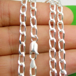 May include: A silver chain necklace with a lobster clasp. The chain is made of a curb link pattern.