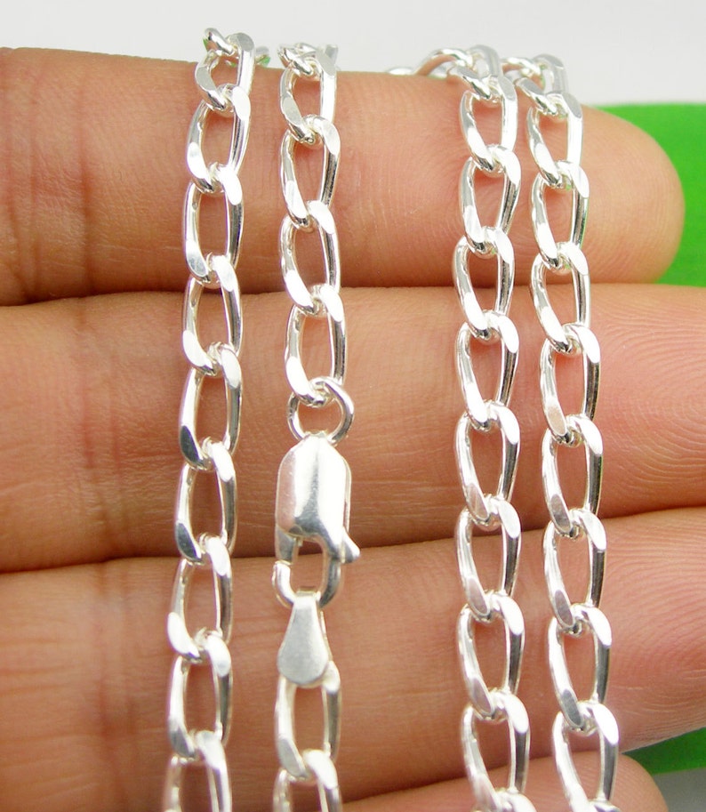 May include: A silver chain necklace with a lobster clasp. The chain is made of a curb link pattern.