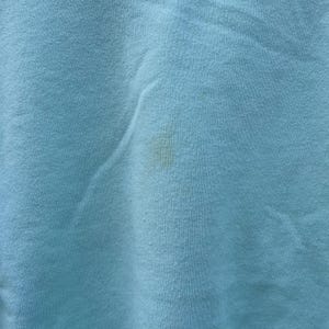 May include: A light blue fabric with a small, light brown stain.