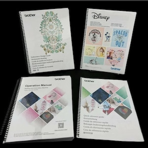 Könnte beinhalten: Vier spiralgebundene Handbücher mit weißen Umschlägen. Eines zeigt ein florales Design, ein anderes Disney-Figuren, und die anderen zeigen geometrische Muster und Text. Die Handbücher sind mit der Marke "Brother" versehen.