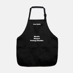 May include: Black apron with a large pocket and white text that reads "Jane Smith World's Okayest Package Handler"
