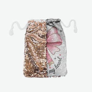 Può includere: Una borsa a cordoncino con un fiocco rosa e il testo "is my heart" su uno sfondo di paillettes argentate. L'altro lato della borsa è in paillettes dorate.
