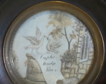 May include: A framed artwork featuring a black and white drawing of two birds with a branch in their beaks. The drawing is set against a background of a stone building and trees. The text "Je t'aime tendre Sire" is written below the birds.