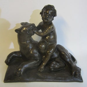 Antique bronze child, playing with a lion or panther; classic bronze