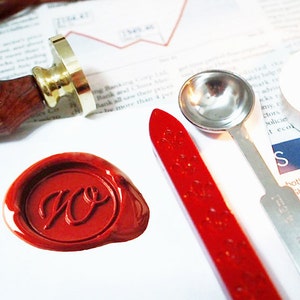以下が含まれることがあります： 「W.O.」のイニシャルが押された赤いワックスシール、木製のハンドルが付いたワックススタンプ、銀のスプーン、赤いワックススティック