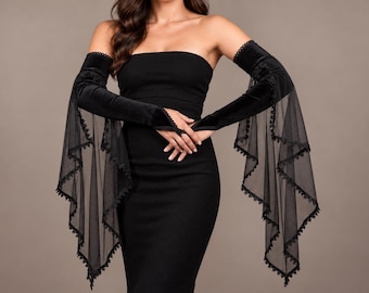 May include: A black strapless dress paired with long, velvet opera gloves that feature flared, sheer mesh sleeves. The sleeves are adorned with delicate lace trim along the edges, extending from the forearm to the wrist in a dramatic, flowing style.