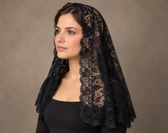 May include: A black lace head covering featuring a detailed floral pattern and a scalloped edge. The fabric is semi-sheer with an intricate weave, draping over the head and shoulders to create a delicate texture and a consistent dark appearance.