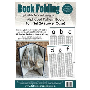 Op de afbeelding: Een boek met vouwpatronen voor boeken met de titel "Book Folding" van Debbi Moore Designs. Het boek bevat 30 kleine letterpatronen, en de omslag toont een gevouwen boekensculptuur van het woord "love".
