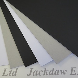 May include: Five sheets of cardstock in different colors: black, white, gray, and two shades of gray. The sheets are arranged in a fan shape.