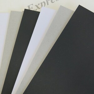 May include: A stack of different colored cardstock paper. The colors are black, white, and gray.