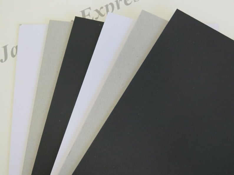 May include: A stack of different colored cardstock paper. The colors are black, white, and gray.