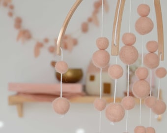 All pink mobile made of felted wool and wood balls