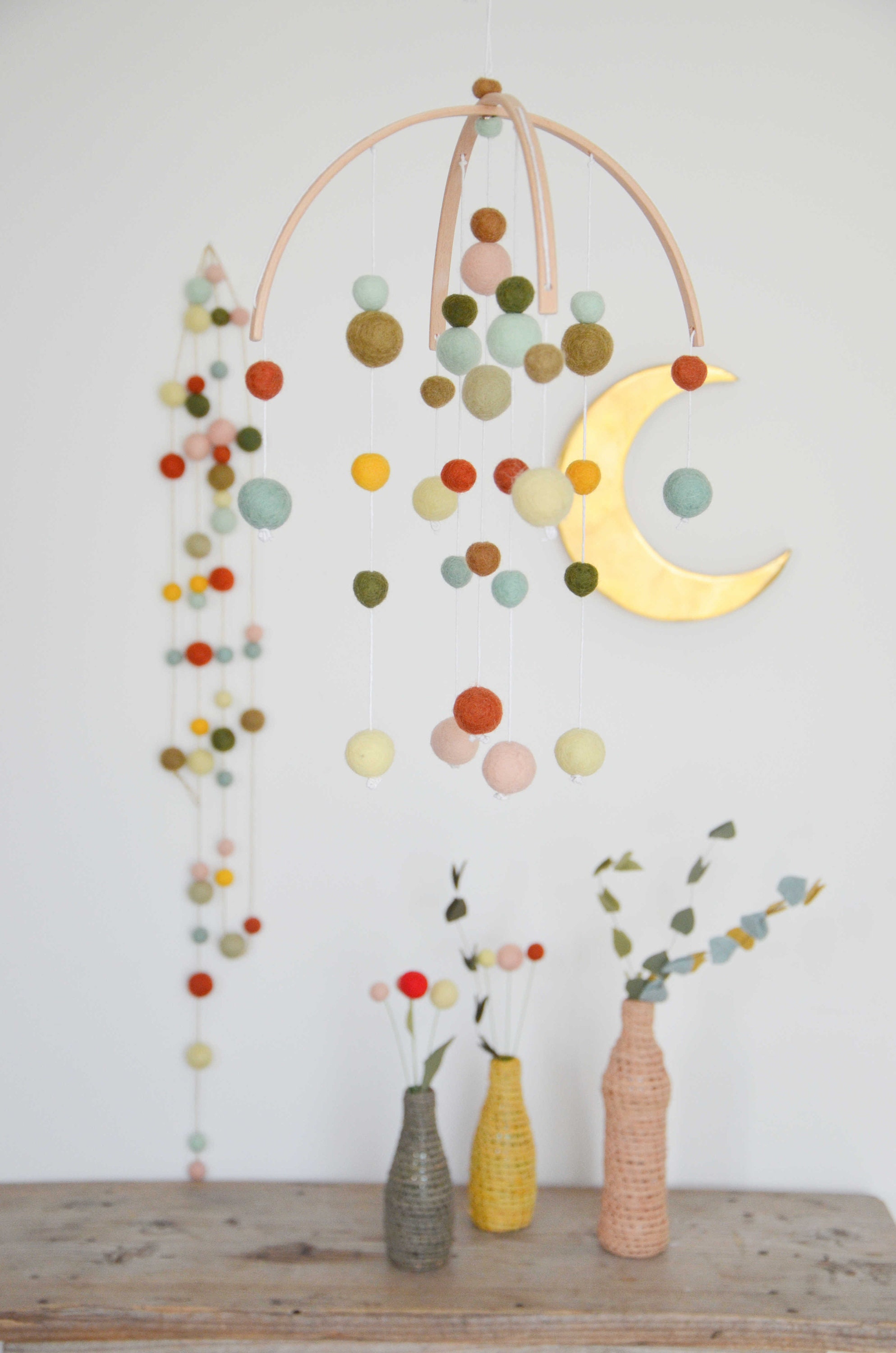 Colorful wooden suspension with mint rust pastel yellow felt balls for decorating birthdays and rooms