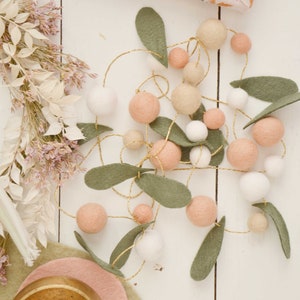 Handgjord tovad ullgirlang med ullblad och filtbollar för hem- och juldekorationer