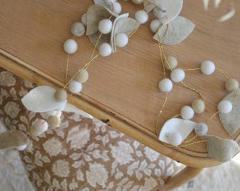 Garland of beige leaves and felted wool balls beige and white tones for the decoration of the house and communions baptisms