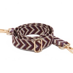Alça para bolsa com estampa chevron em tons de bordô, roxo e bege; Alça para carteira com detalhes em dourado.