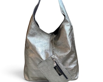May include: A metallic silver hobo bag with a slouchy silhouette and a single shoulder strap. Attached to the bag by a thin silver chain is a small rectangular zippered pouch featuring a black label that reads Genuine Leather Made in Italy.