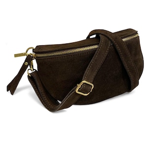 May include: A dark brown suede fanny pack with a gold zipper and hardware. The adjustable strap is also dark brown and features a gold buckle. The bag has a minimalist design and is suitable for everyday use.