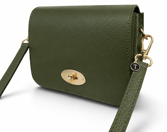 May include: An olive green leather crossbody bag with a textured finish, featuring a gold-toned metal turn-lock closure on the front flap. The bag includes a matching olive green shoulder strap attached with gold-toned hardware and a small circular charm with the letter T.