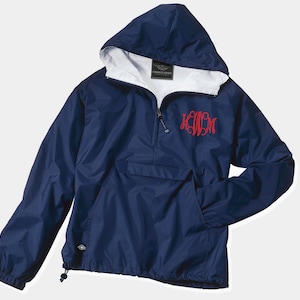 May include: A navy blue hooded windbreaker with a red monogram on the front. The jacket has a zipper closure and a kangaroo pocket.
