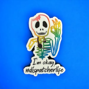 May include: A rainbow skeleton with a headset and the text "I'm okay #dispatcherlife" on a blue background.