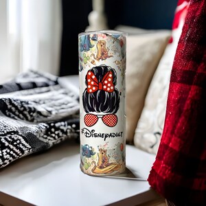 May include: White stainless steel tumbler with a colorful design featuring Disney characters and the text "#DisneyAdult".