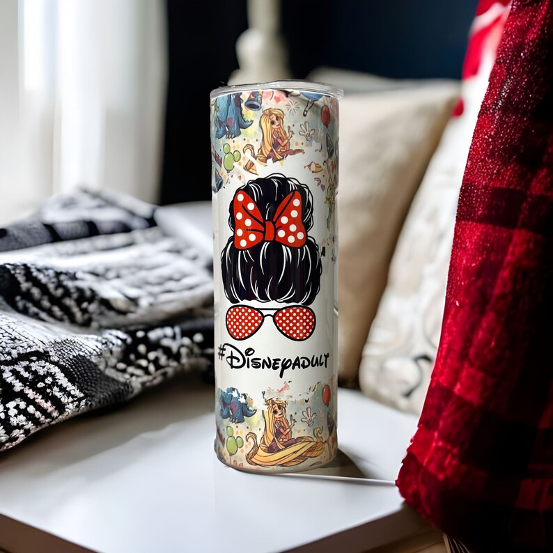 May include: White stainless steel tumbler with a colorful design featuring Disney characters and the text "#DisneyAdult".