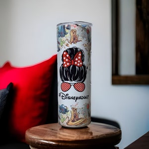 May include: White stainless steel tumbler with a colorful design featuring Disney characters and the text "#DisneyAdult".