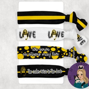 May include: Set of four black and yellow hair ties with different designs. The first hair tie is black and yellow stripes. The second hair tie is white with the word "LOVE" and a black and yellow headset. The third hair tie is black with yellow polka dots and the text "We serve so others may live". The fourth hair tie is black with the text "the calm voice in the dark" and a black and yellow headset.