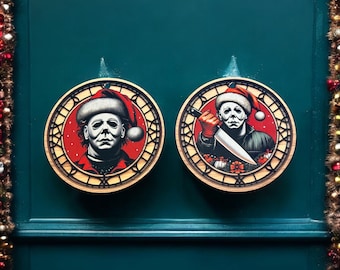 May include: Two round, wooden ornaments with a red and white Christmas theme. The ornaments feature a character wearing a Santa hat and holding a knife. The ornaments are hanging on a teal green wall.