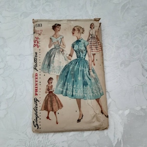 Puede incluir: Patrón de costura vintage Simplicity para un vestido, número de patrón 1583, talla 13. El patrón muestra tres estilos diferentes de vestidos, uno con una falda a cuadros, otro con una falda azul sólida y otro con una falda blanca. El patrón está impreso en papel marrón claro.