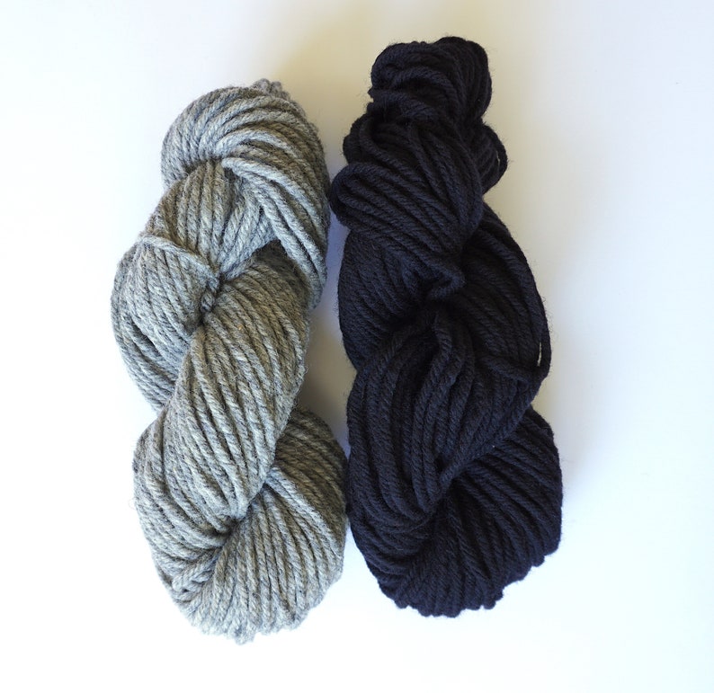 May include: Two skeins of yarn, one gray and one black. The yarn is thick and soft, perfect for knitting or crocheting.