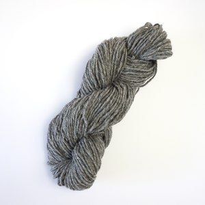 May include: A skein of gray yarn, twisted and ready for knitting or crocheting.