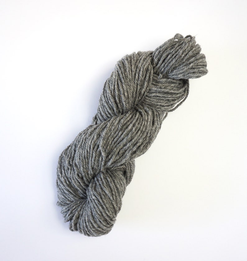 May include: A skein of gray yarn, twisted and ready for knitting or crocheting.