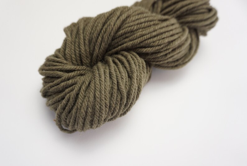 Puede incluir: Un ovillo de hilo verde oscuro, perfecto para tejer o hacer ganchillo.