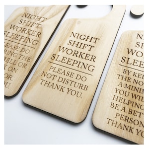 Może przedstawiać: Trzy drewniane wieszaki na drzwi z tekstem "Night Shift Worker Sleeping" i "Please Do Not Disturb Thank You".