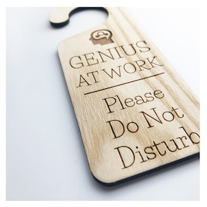 May include: Wooden door hanger with the text "Genius at work" and "Please do not disturb".