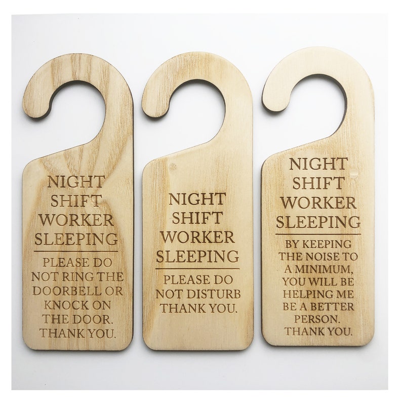 Może przedstawiać: Trzy drewniane wieszaki na drzwi z tekstem "Night Shift Worker Sleeping" i r&oacute;żnymi wiadomościami o szanowaniu snu pracownika nocnego.